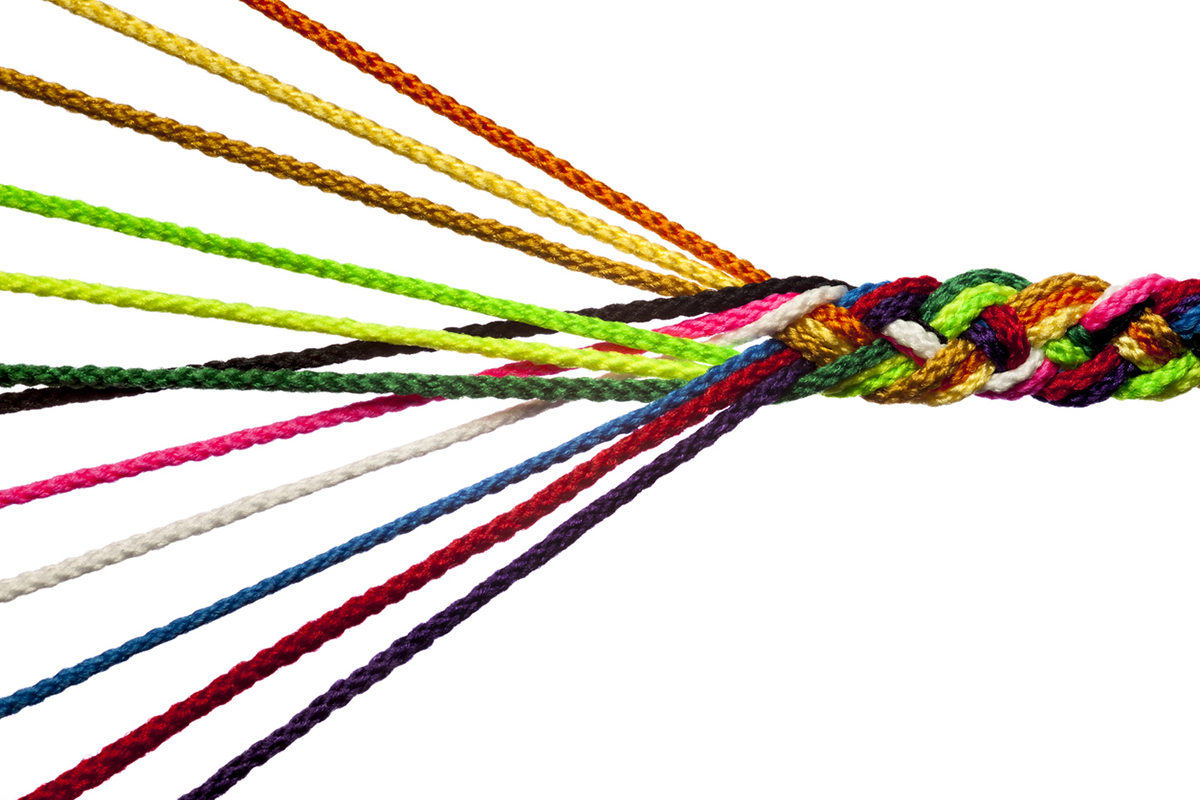 Colorful threads being woven into a thicker strand to illustrate the concept of a holistic approach to psychographic segmentation.
